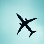 A striking silhouette of an airplane flying overhead against a light blue sky in Mexico City.